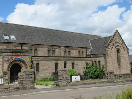 Richmond Craigmillar Parish church is a long brown stone church.