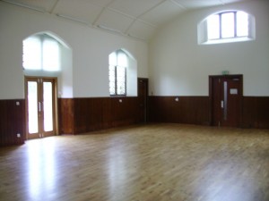 A large hall with a high ceiling and a wooden floor